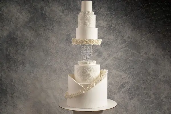 کیک عروسی : سه طبقه کوچک در بالا و سه طبقه در پایین . بین دو بخش کریستا آویزان و فضا خالی است