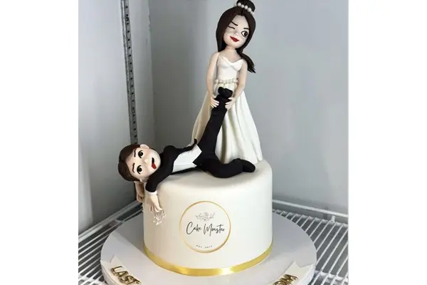 کیک عروس فانتزی مجسمه عروس ایستاده و در حال کشیدن داماد روی کیک